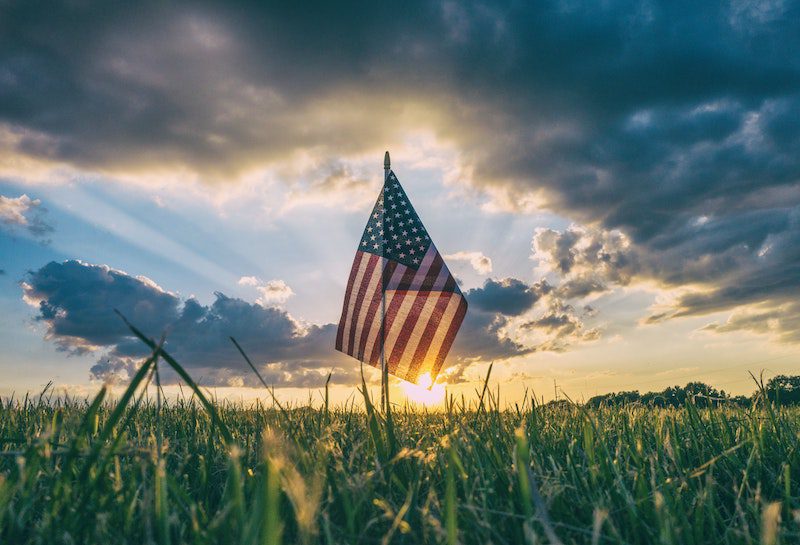 American flag with the sun setting behind it